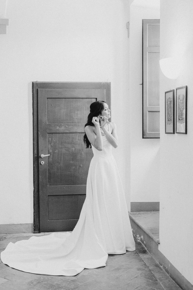 Mariée mettant ses boucles d&rsquo;oreilles, photo en noir et blanc